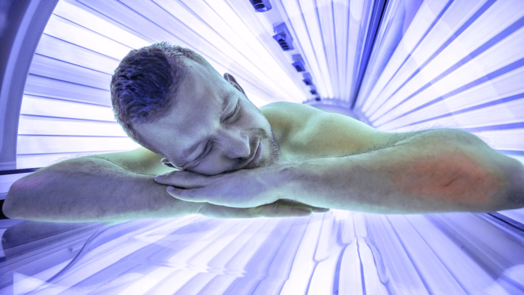 Ein Mann liegt auf einer Sonnenbank im Solarium und entspannt.